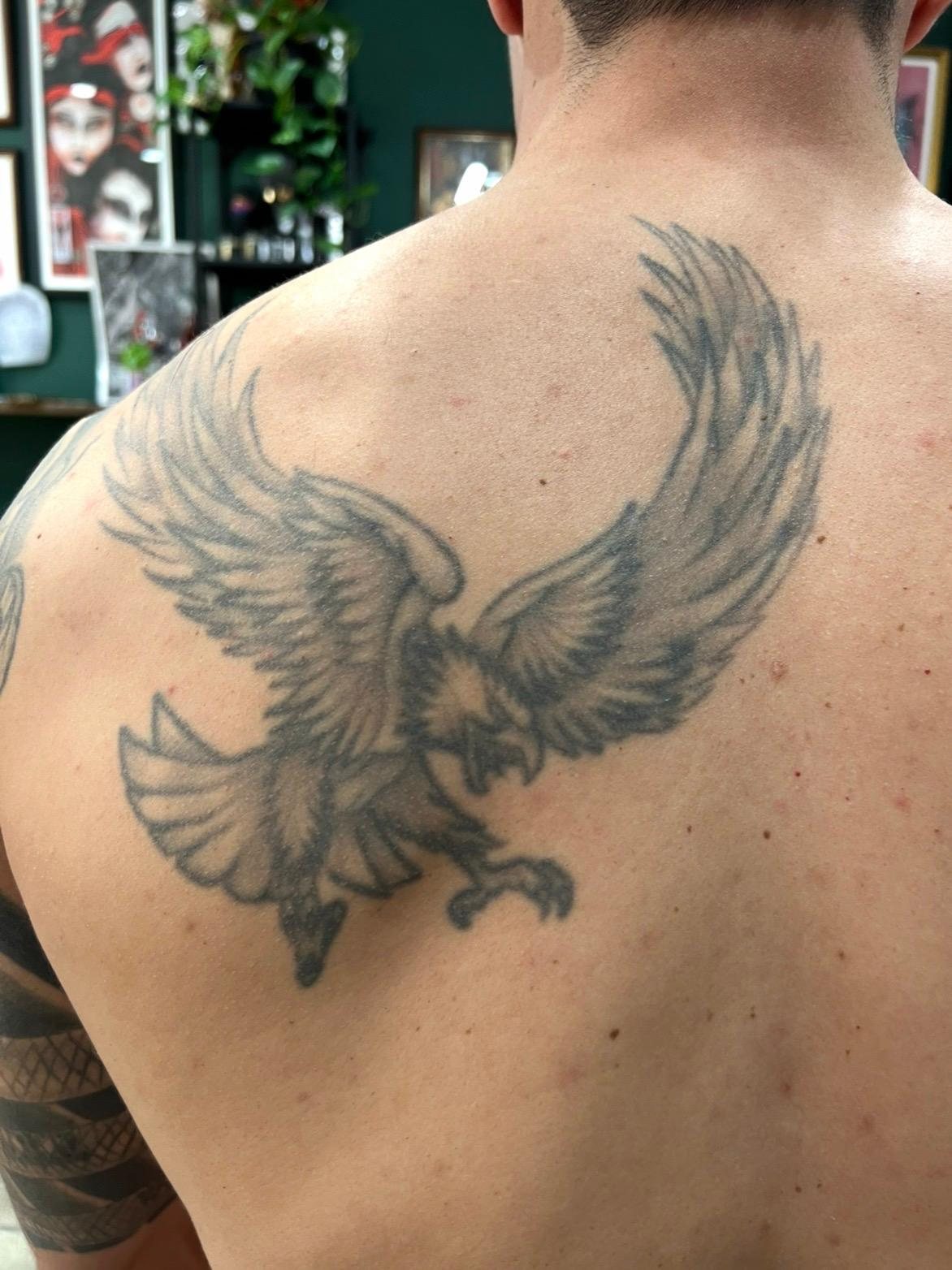 Eagle tattoo on the upper back before treatment